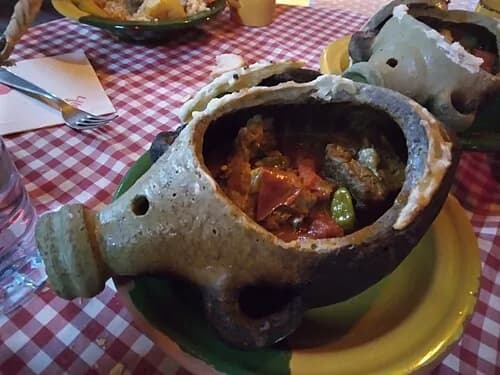 Jarre en terre brisée révélant la viande de dromadaire mijotée